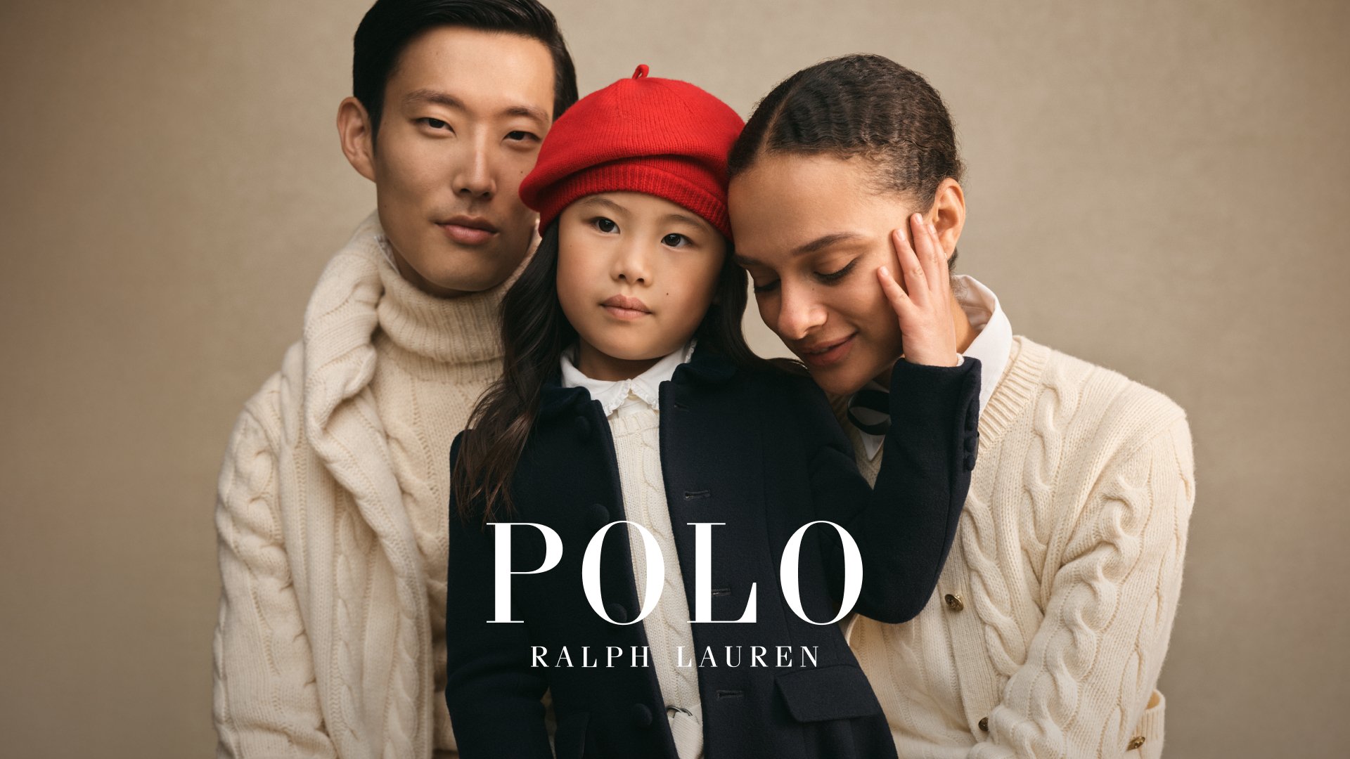 Tre personer i koordinerade kläder: en krämfärgad kabelstickad tröja, mörk kappa, vit skjorta och en röd basker på ett barn, mot en neutral bakgrund.