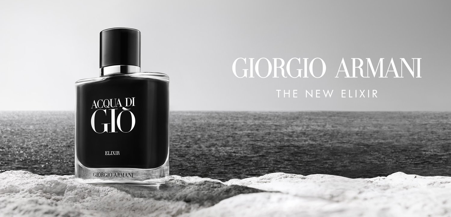 Schwarze Glasparfümflasche mit einem silbernen Deckel, beschriftet mit "Acqua di Giò Elixir" von Giorgio Armani, vor einem grauen Hintergrund.