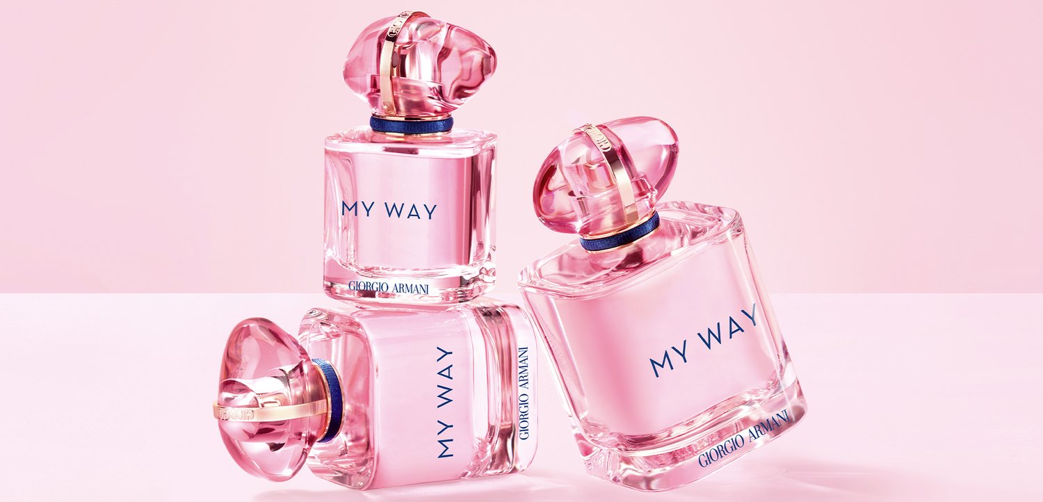 Three pink Giorgio Armani "My Way" perfume bottles arranged on a pale pink surface and background.