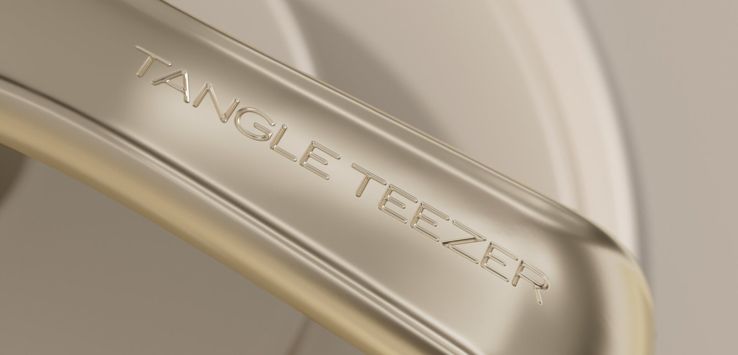 Close-up van een beige haarborstelhandvat met het merk TANGLE TEEZER erin geperst.