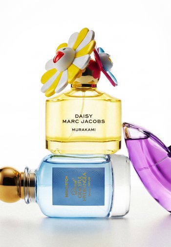 Geel Marc Jacobs Daisy Murakami parfumflesje met bloemdop gestapeld op een blauwe Bridgeton Graceful Hydrangea fles en een paarse fles met abstracte vorm.