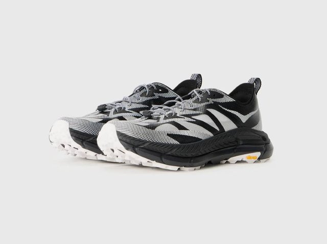 Αθλητικά παπούτσια ασπρόμαυρα με υφαντό πλεκτό πάνω μέρος με υφή, κυρτή σχεδίαση, έντονη λαστιχένια σόλα και ανακλαστικές λεπτομέρειες.