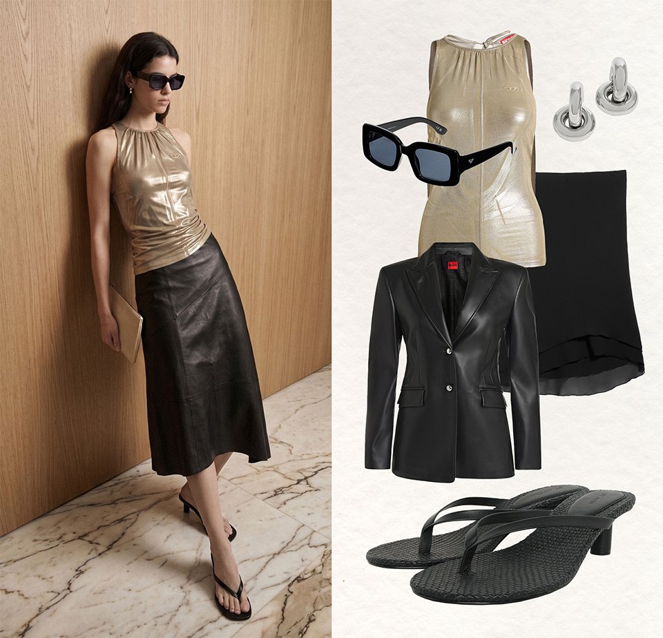 Femme portant des lunettes de soleil, un haut doré sans manches, une jupe midi en cuir noire, des sandales noires à talons, tenant une pochette dorée, appuyée contre un mur en bois.