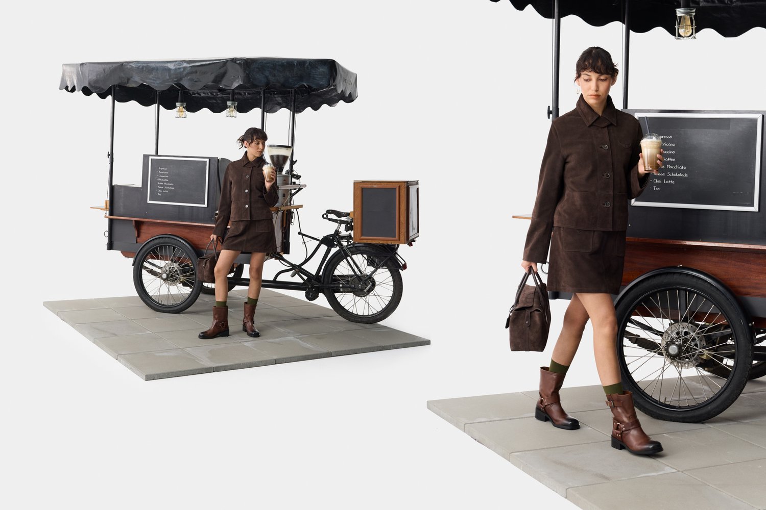 Conjunto de chaqueta y falda de ante marrón, botas de tobillo de cuero marrón, llevando un bolso marrón, junto a un carrito de café de bicicleta con un toldo negro.