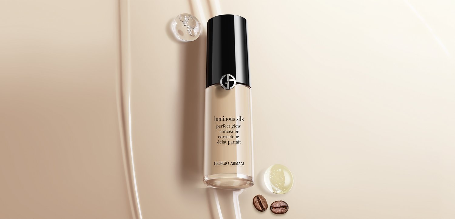 Giorgio Armani Luminous Silk Perfect Glow Concealer-Flasche mit Kaffeebohnen und Tropfen Flüssigkeit auf beigem Hintergrund.