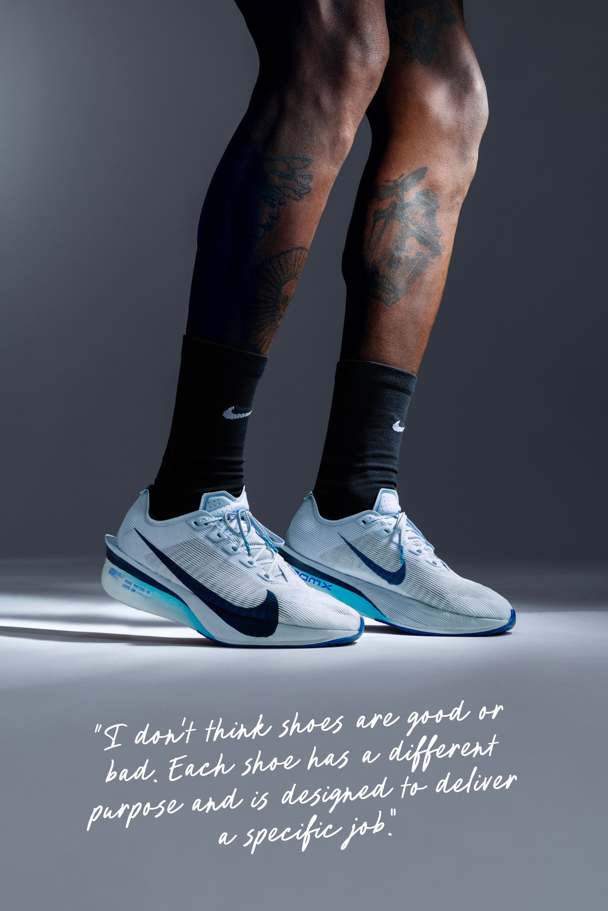 Hellblaue Laufschuhe mit einem dunkelblauen Nike-Swoosh, strukturiertem Obermaterial und gepolsterter Sohle. Schwarze Socken sind über den Schuhen sichtbar.