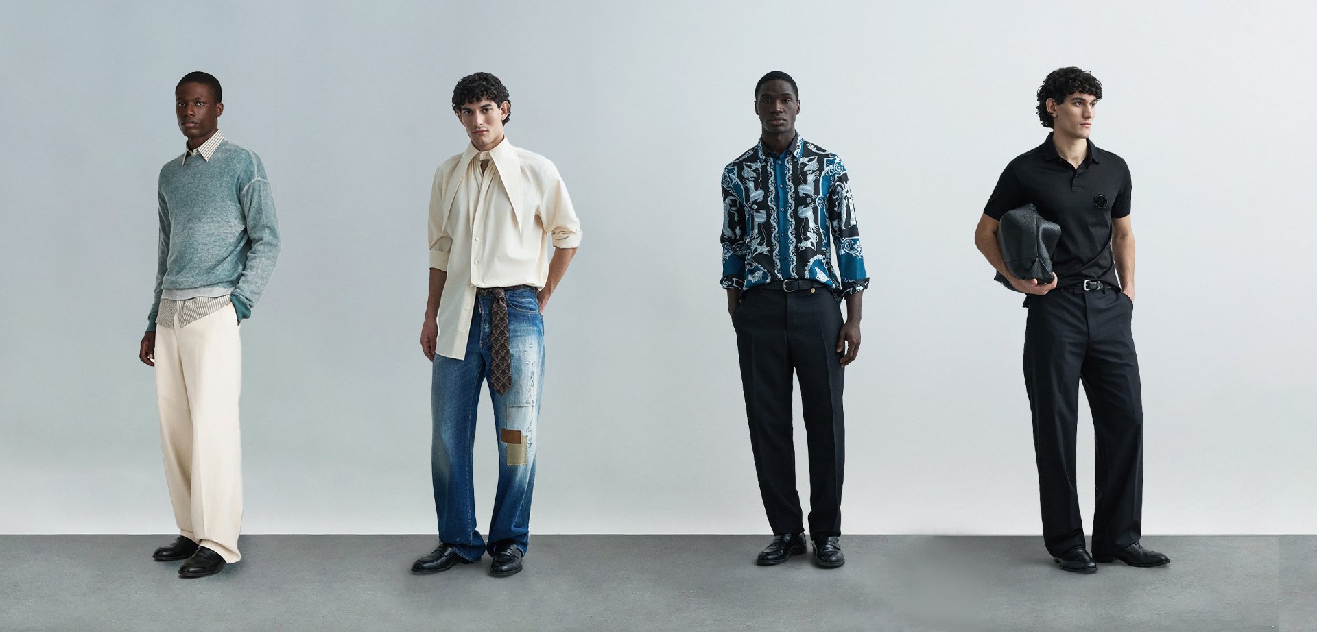 Quatro modelos masculinos posam contra um fundo claro, vestindo uma mistura de texturas e cores: um suéter verde-azulado, uma camisa creme, uma camisa estampada e uma polo preta.