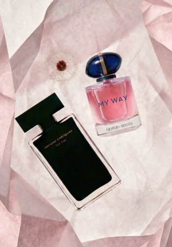 Dwie butelki perfum — Narciso Rodriguez for her w czerni oraz Giorgio Armani My Way w różu z niebieską nakrętką — na pomarszczonym różowym papierze.