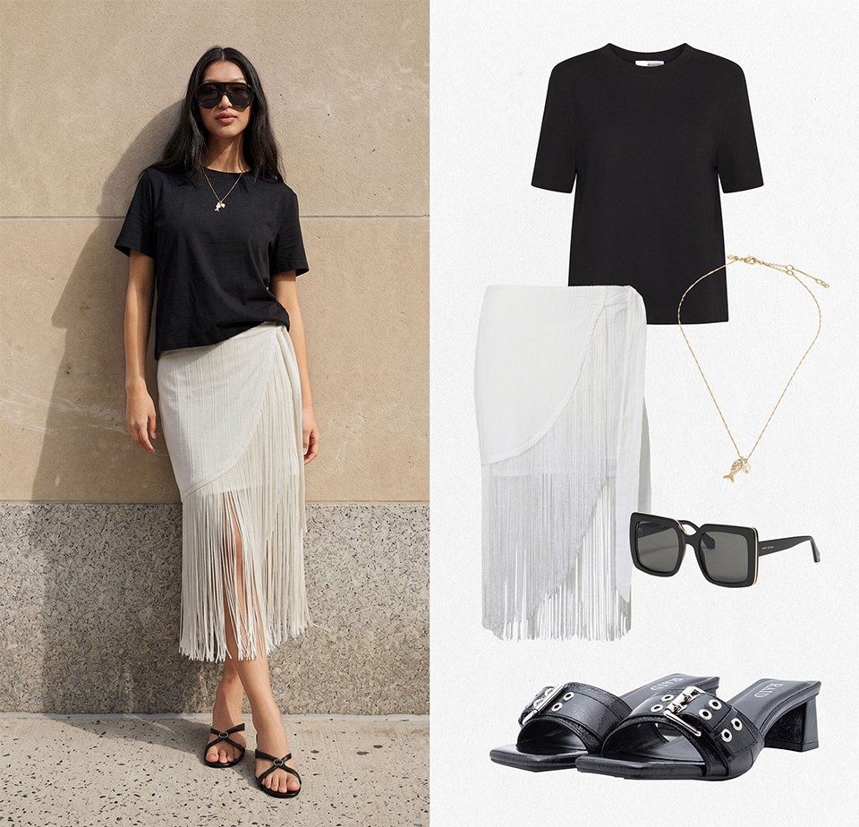 Femme portant un T-shirt noir, une jupe blanche à franges, des sandales noires, des lunettes de soleil noires et un collier doré, debout à l’extérieur ; les pièces de la tenue sont montrées à côté d’elle.