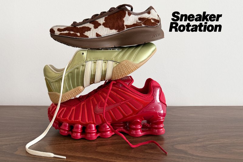 Drei übereinander gestapelte Sneaker auf einer Holzoberfläche: braun-weiß mit Kuhmuster, gold mit weißen Streifen und rot mit federnden Sohlen.