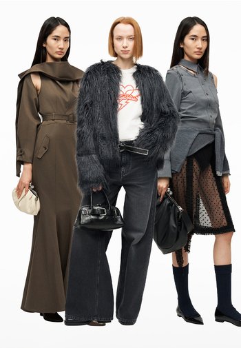 Drie vrouwen dragen modieuze outfits: een bruine jurk met ceintuur en open schouders, een grijze jas van nepbont met zwarte jeans, en een grijs shirt met een doorschijnende rok met polkadotprint.