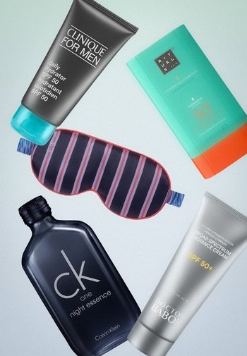 Tube en flesjes voor mannenhuidverzorging met SPF 50+, een gestreepte slaapmasker met elastische band, gerangschikt op een lichte ondergrond.