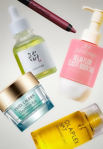 Fünf Kosmetikprodukte: grüne Tropfflasche mit koreanischem Text, rosa SOL DE JANEIRO Körperöl, blaue Estee Lauder Augencreme, gelbes Olaplex Bindungsöl und ein MAC Lippenkonturenstift.