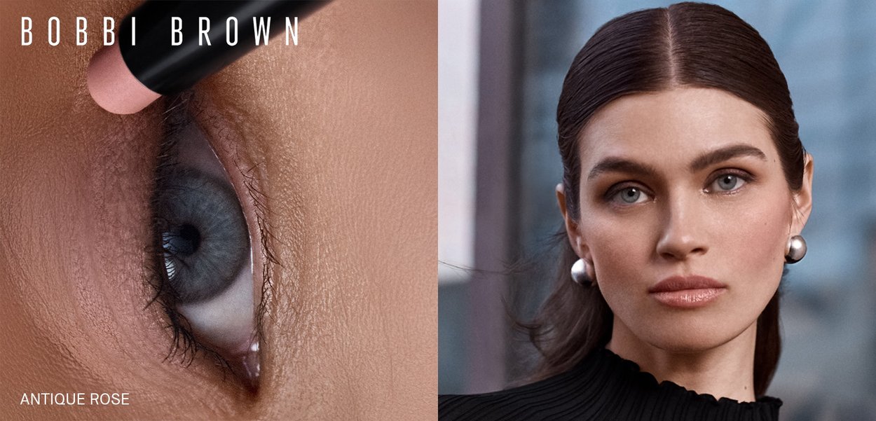 Bobbi Brown Antique Rose eye pencil applies a soft pink tone on a detailed close-up of the eye, paired with a model featuring a sleek hairstyle and pearl earrings.
