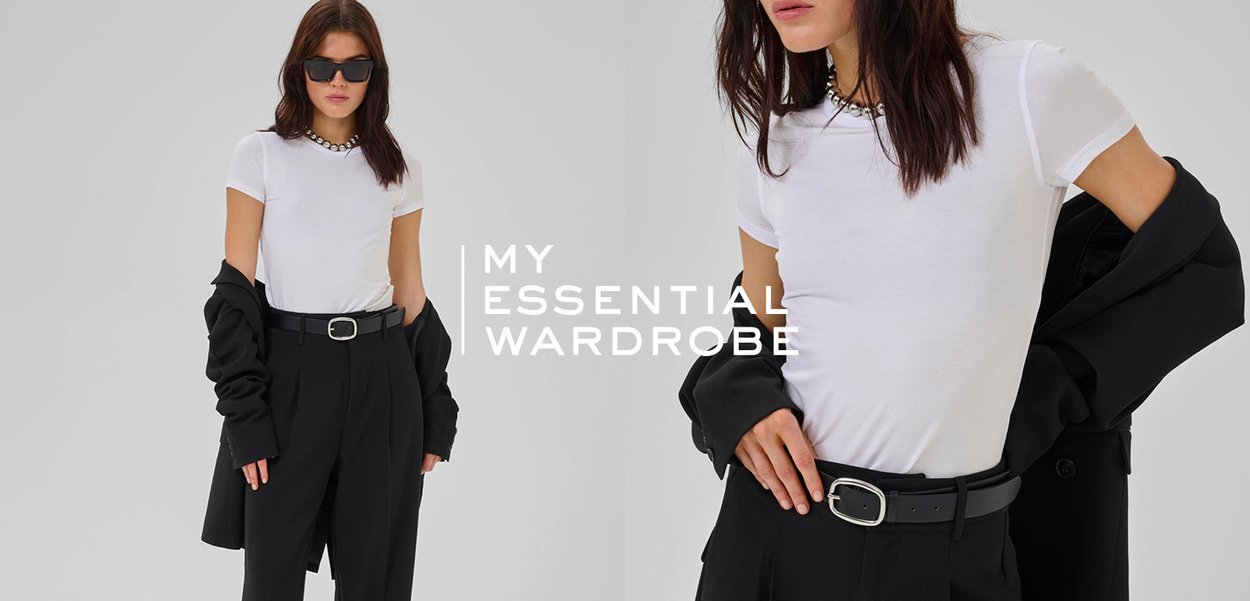 White fitted t-shirt paired with high-waisted black trousers. Model wears a black oversized coat, sunglasses, and a pearl necklace.