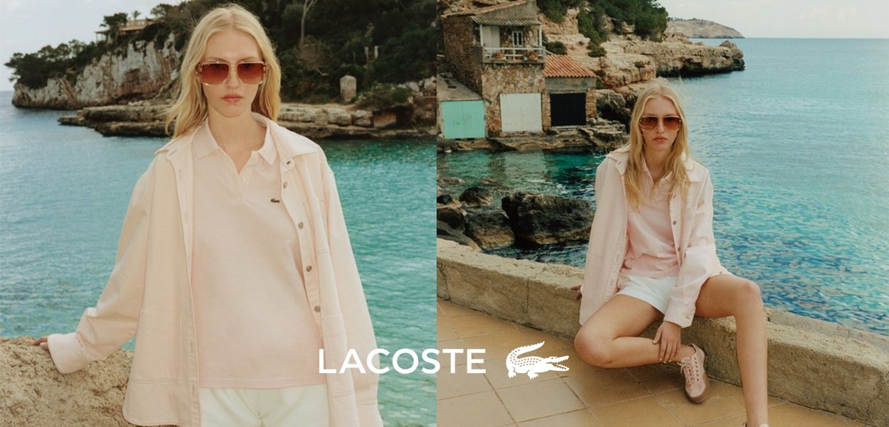 Polo shirt rosa chiaro sotto una giacca leggera, pantaloncini bianchi e sneaker rosa. Modello che indossa occhiali da sole contro uno sfondo costiero.
