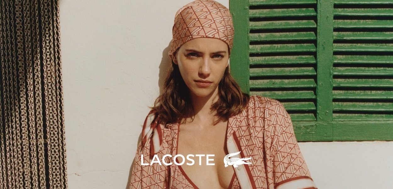Traje de baño de Lacoste en una tela con patrón geométrico, que presenta una mezcla de colores rosa y beige, con detalles de acento a lo largo de los bordes y un pañuelo a juego.