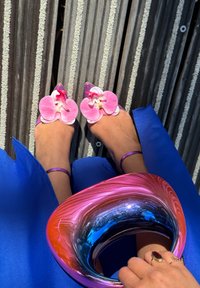 Sandales à talons violettes avec de grandes ornements d'orchidées roses. Accessoire présentant un dégradé tourbillonnant de rose, violet et bleu.
