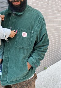 Πράσινο βελούδινο μπουφάν με τσέπη στο στήθος, κλείσιμο με κουμπιά και ραβδωτή υφή. Διαθέτει πλάκα λογότυπου και κουμπιά στα μανίκια.