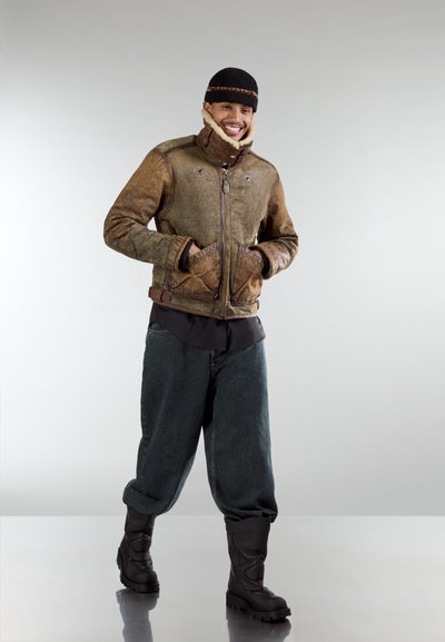 Chaqueta de cuero marrón con cuello de piel, cremallera frontal y bolsillos; combinada con pantalones oscuros holgados y botas negras impermeables.