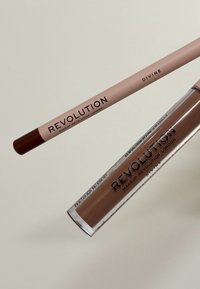 Crayon à lèvres Makeup Revolution en rose doux avec une pointe marron, accompagné d'un rouge à lèvres liquide dans un tube marron mat, tous deux étiquetés "Divine."