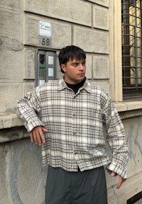 Beige és szürke árnyalatú, hosszú ujjú kockás ing, laza szabással, gombos elejével és puha anyaggal.