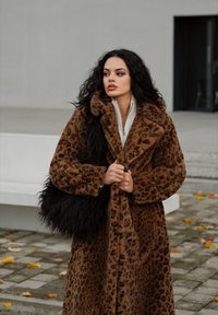 Pruun leopardimustriga mantel, mis on valmistatud pehmest kangast, millel on karvane tekstuur, suur krae ja sobiv must koheva käekott.