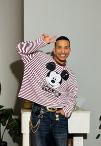 Juostuotas ilgomis rankovėmis marškinėlis su Mikio pelėdos atvaizdu. Dėvimas su tamsiomis džinsomis ir grandinėlės akcentu. Lygi medžiaga ir laisvas kirpimas.