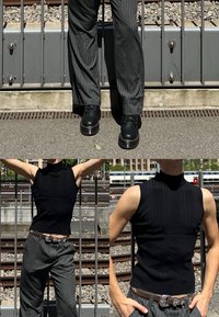 Melnīga, bezroku, ribota topiņa ar viltus apkakli; kopā ar pelēkām svītrainām biksēm un masīvām melnām kurpēm ar sudrabotu akcentu. Teksturēts dizains.