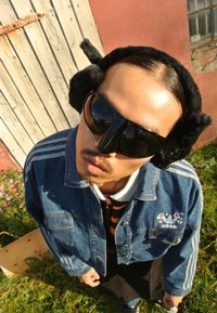 Τζάκετ από τζιν με κεντημένα λουλούδια και τρεις ρίγες, υπερμεγέθη μαύρα γυαλιά ηλίου και μαύρες γούνινες ακουστικές, σε μια υφασμένη φόντο.