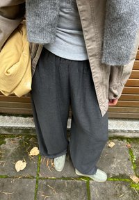 Grå, bredbukser med elastisk talje, parret med en lysegrå top og beige overtøj, suppleret med lysegrønne sko.