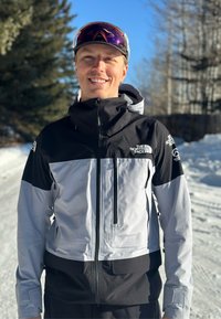 Télies kabát, fekete és szürke színben, vízálló anyagból, cipzáras zsebekkel, állítható kapucnival és logós részletekkel.
