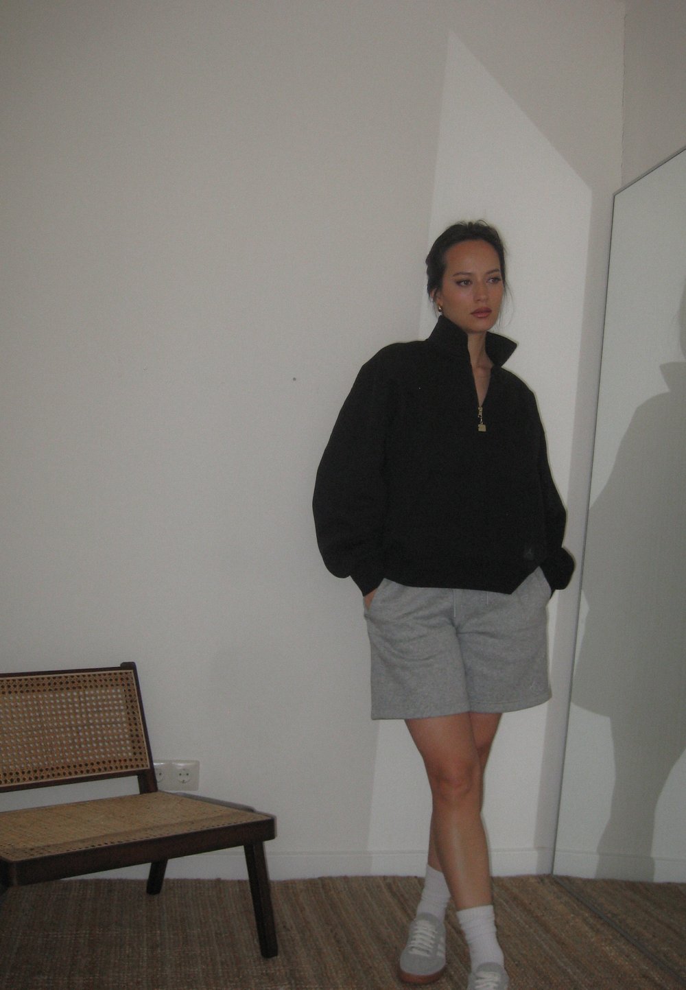 Μαύρη ζακέτα με φερμουάρ, ανοιχτό γκρι σορτς, λευκές κάλτσες και γκρι αθλητικά παπούτσια. Μαλακό ύφασμα, άνετη εφαρμογή, εμφανής ανακλαστική λεπτομέρεια στη ζακέτα.