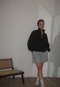 Μαύρη ζακέτα με φερμουάρ, ανοιχτό γκρι σορτς, λευκές κάλτσες και γκρι αθλητικά παπούτσια. Μαλακό ύφασμα, άνετη εφαρμογή, εμφανής ανακλαστική λεπτομέρεια στη ζακέτα.