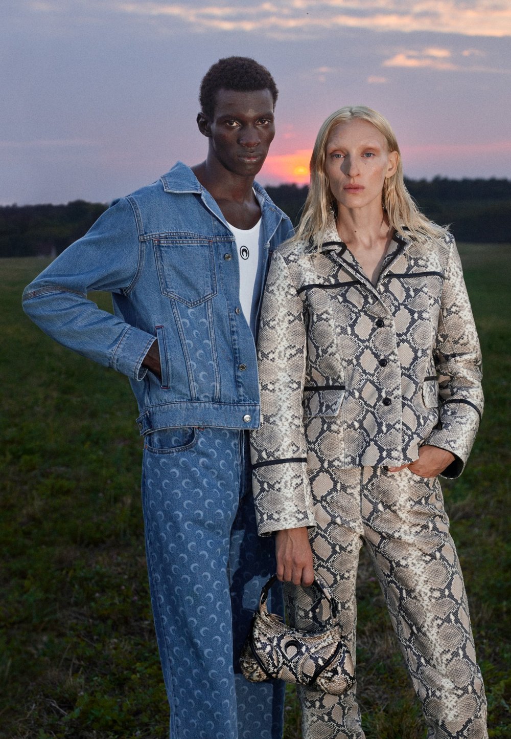 Denimjakke med lommer, blå jeans med halvmånemønstre og en mønstret slangetryksdragt. Teksturkonstrast og strømlinet design.