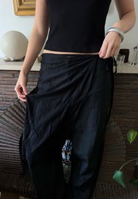 Mustad musträbiga püksid, millel on tekstuuriga lillemuster, valmistatud kerge kangaga. Omab reguleeritavaid sidemeid ja lahtist, voolavat disaini.