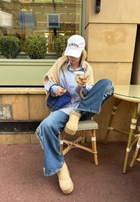 Καθημερινό ντύσιμο με ανοιχτό μπλε καρό πουκάμισο, μπεζ πουλόβερ, φθαρμένα μπλε τζιν και καφέ πλατφόρμες. Μπλε τσάντα με μοτίβο και ρόφημα στο χέρι.