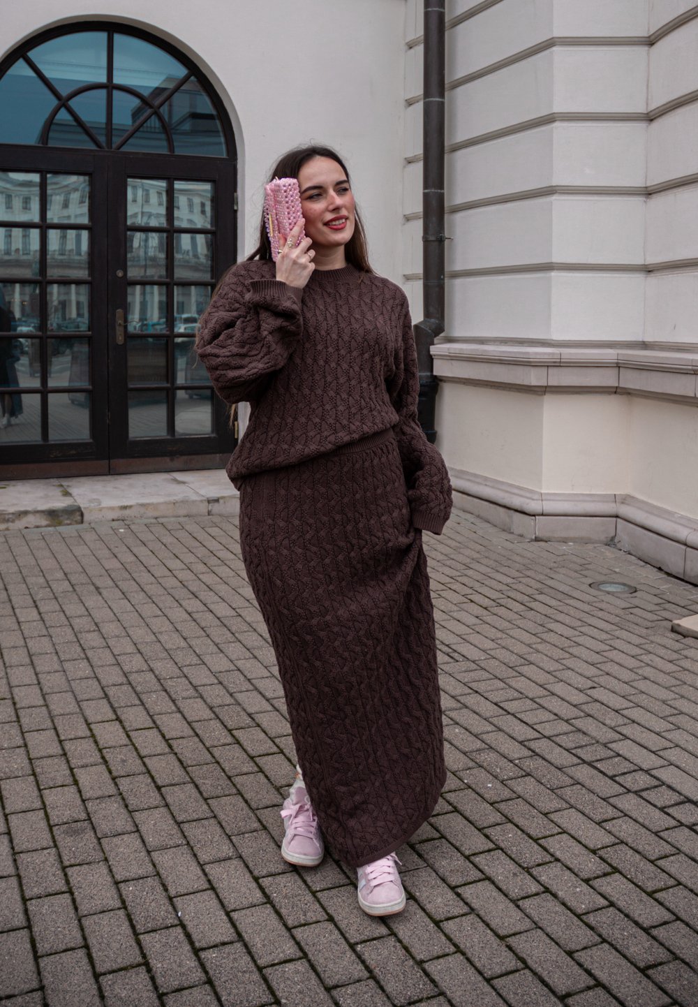 Pull en tricot marron et jupe assortie avec un motif texturé. Tissu doux, coupe décontractée, assortis à des baskets roses et une pochette rose.