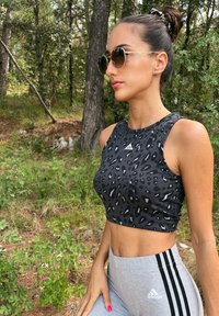 Μαύρο τοπ σε μπούστο με λεοπάρ σχέδιο, με στρογγυλή λαιμόκοψη και χωρίς μανίκια. Συνδυάζεται με γκρι κολάν που έχουν τρεις μαύρες ρίγες.