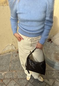 Svetlo modra, rebrasta, puhasta jopica; krem hlače širokih hlačnic; temno rjava tkaninska torbica s trakom za ramo; bele čevlje z različnimi poudarki.