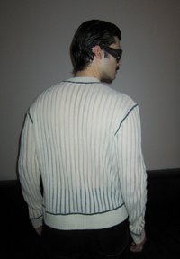 Pull rayé crème avec des lignes bleues et roses, texture côtelée, col rond et silhouette ajustée, avec des manches longues.