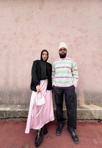 Μαύρο φούτερ με φερμουάρ, ροζ φούστα και μικρή ροζ τσάντα στα αριστερά; ριγέ παστέλ πουλόβερ και μαύρο cargo παντελόνι στα δεξιά.