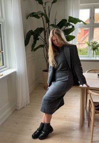 Grijze wollen mix jurk met een bijpassende blazer, chunkyzwarte loafers en grijze sokken. Soepele textuur; op maat gemaakte pasvorm; ontwerp met lange mouwen.