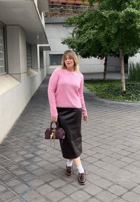 Różowy sweter prążkowany z kołnierzykiem, czarna skórzana spódnica midi, brązowe buty na sznurówki, białe skarpetki i bordowa torebka z ozdobami.
