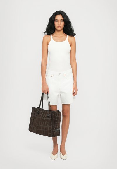 Top blanco de tirantes, pantalones cortos de denim blanco y zapatos beiges de punta. Bolsa tote de textura de cocodrilo marrón oscuro con asas negras.