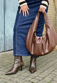 Ruda dirbtinės odos rankinė su susiraukšlėtu dizainu, derinama su rudomis aštriu nosimi ankletinėmis botais, turinčiais stiletto kulną ir užtrauktuką.