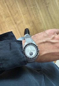 Orologio in acciaio inossidabile argento con quadrante bianco, sub-quadrante nero e ghiera nera. Caratterizzato da un bracciale a maglie e un design della cassa rotonda.