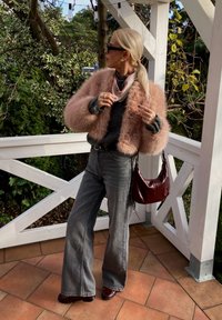 Φουντωτό ροζ κοντό μπουφάν, γκρίζες υπερμεγέθεις τζιν παντελόνες, σκούρο κόκκινο δερμάτινο τσαντάκι και μποτάκια μέχρι τον αστράγαλο. Σα scarf με σχέδιο γύρω από τον λαιμό, μοντέρνος σχεδιασμός.