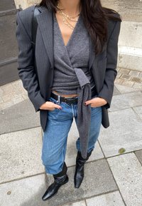 Črn blejzer s pinstripes, siva ovita majica, modri hlače z visokim pasom, črn pas, črne škornje do kolen. Teksturne tkanine, prilagojen kroj.