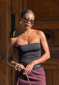 Mustamata must topp, burgundi seelik, kuldsed aksessuaarid. Päikeseprillid, punutud soeng. Seismine puidust taustal.